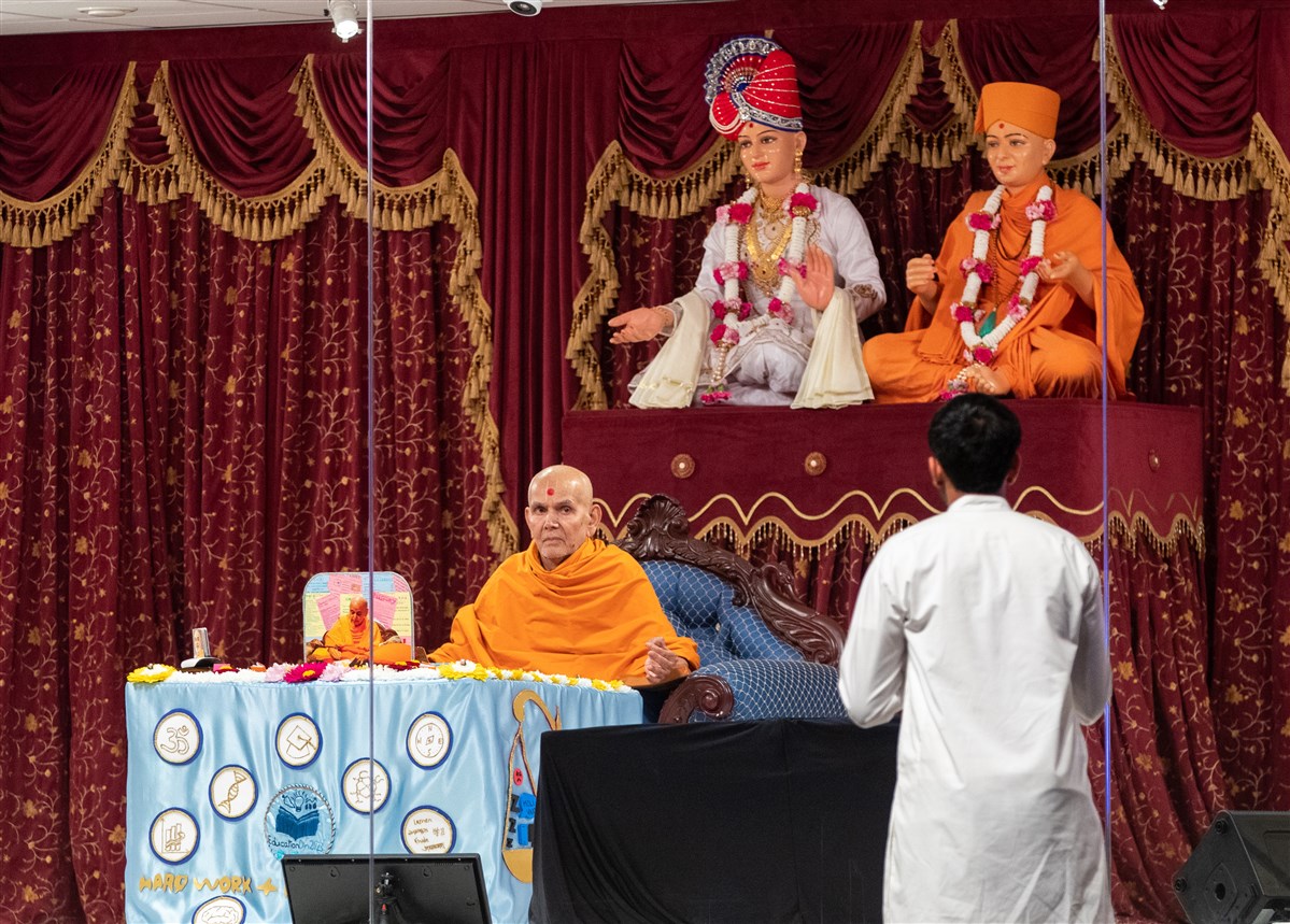 Swamishri listens attentively to the children and youths as he performs his puja