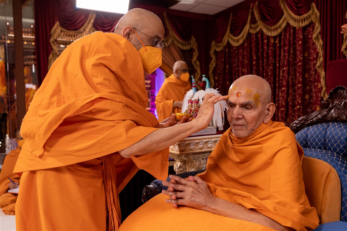Aksharviharidas Swami performs Thakorji's pujan and applies archa on Swamishri's forehead