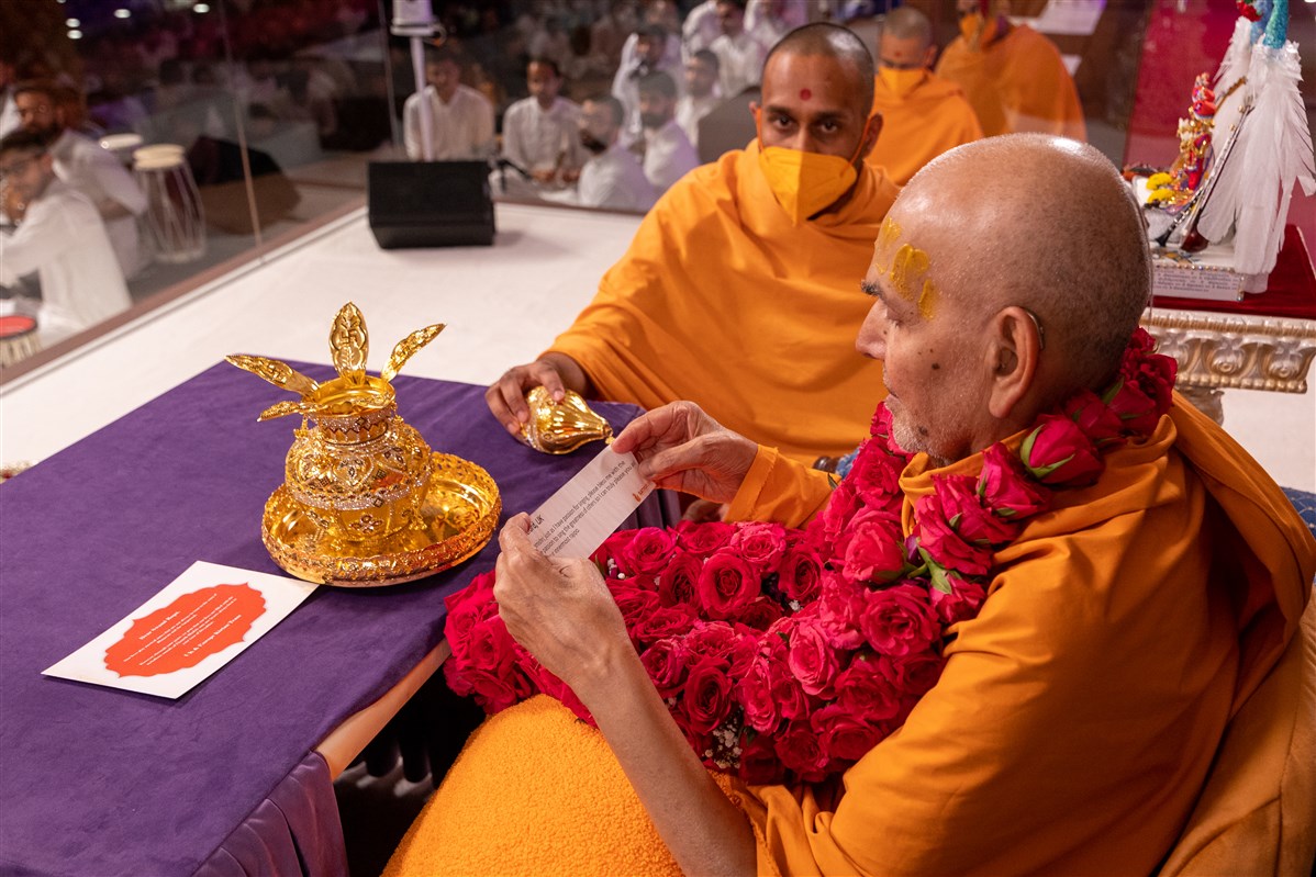 Swamishri reads a prayer from a devotee offered within the kalash