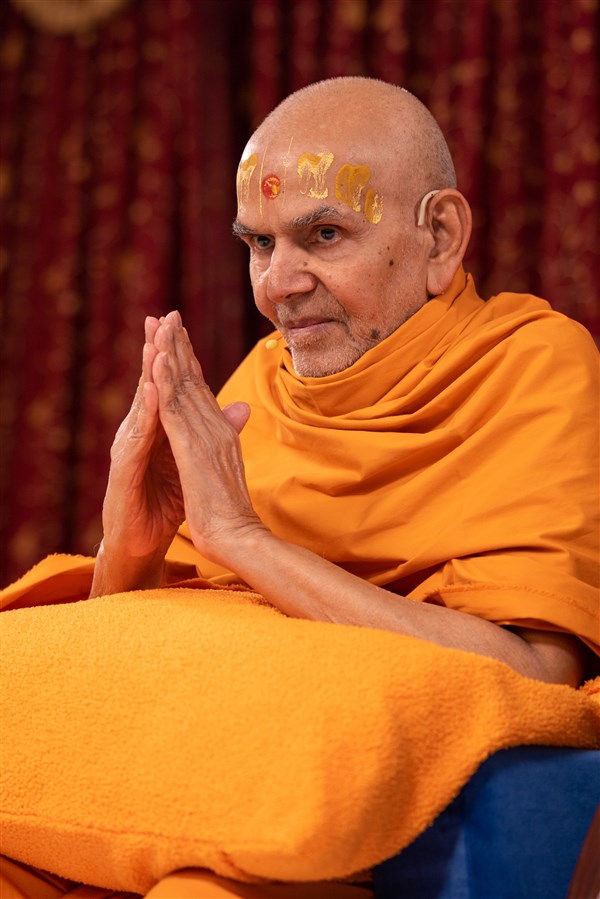 Swamishri humbly accepts everyone's applause and cheers with folded hands