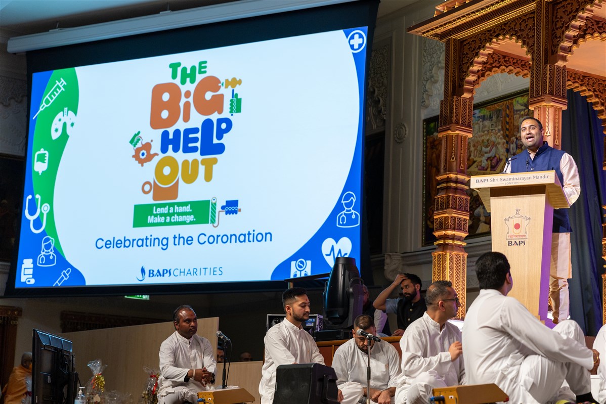 Dr Nirav Amin, a BAPS volunteer, presents a brief overview of how Neasden Temple and BAPS Charities participated in ‘The Big Help Out’ <br>To learn more, please click <a href="https://www.baps.org/News/2023/Coronation-Big-Help-Out-at-BAPS-Shri-Swaminarayan-Mandir-23526.aspx" target="blank" style="text-decoration:underline; color:blue;" >here</a>