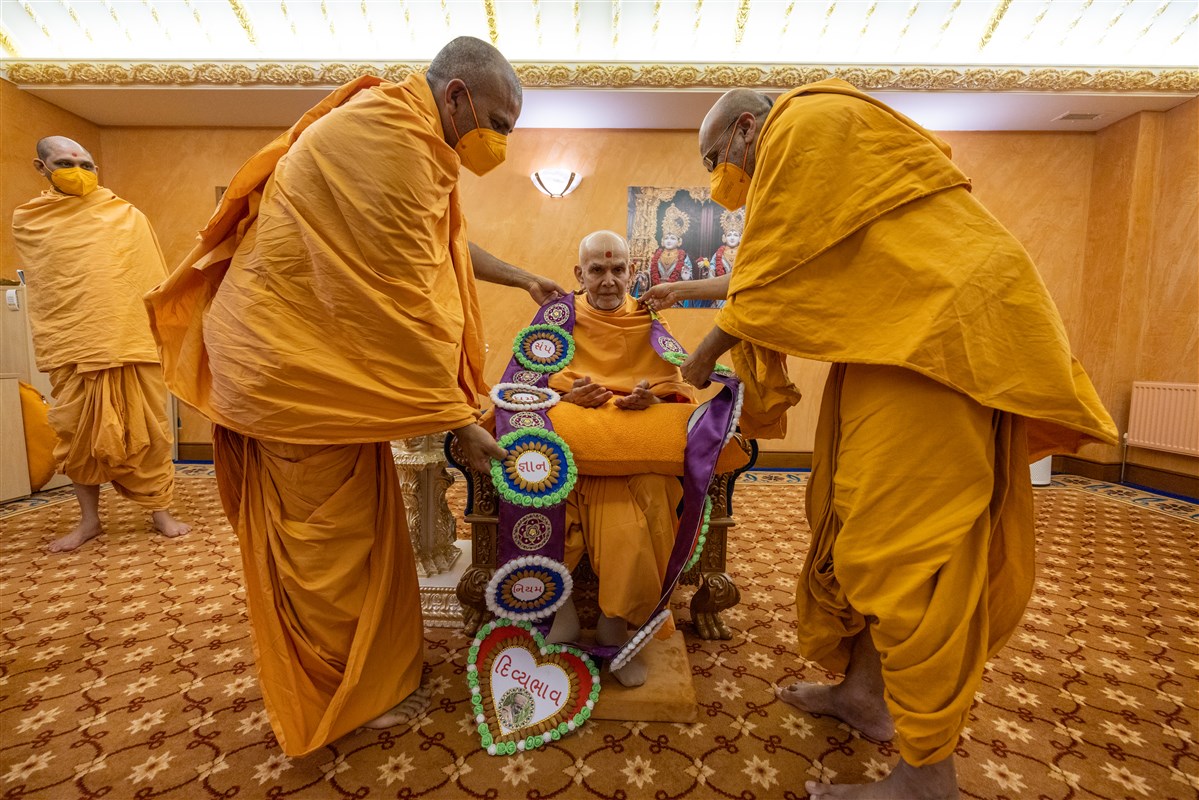 Munirajdas Swami and Bhaktiswarupdas Swami honour Swamishri with a decorative garland