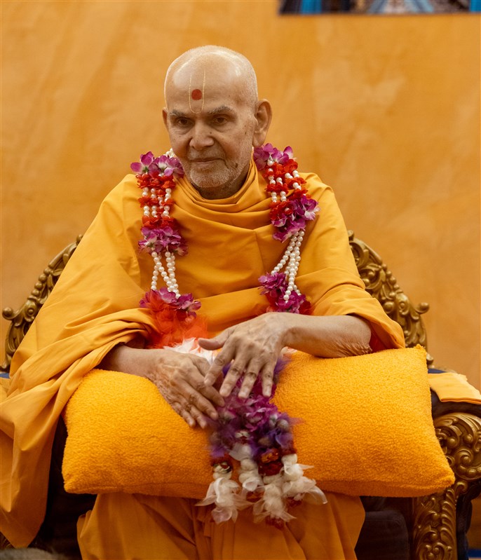 Swamishri is honoured with a decorative flower garland