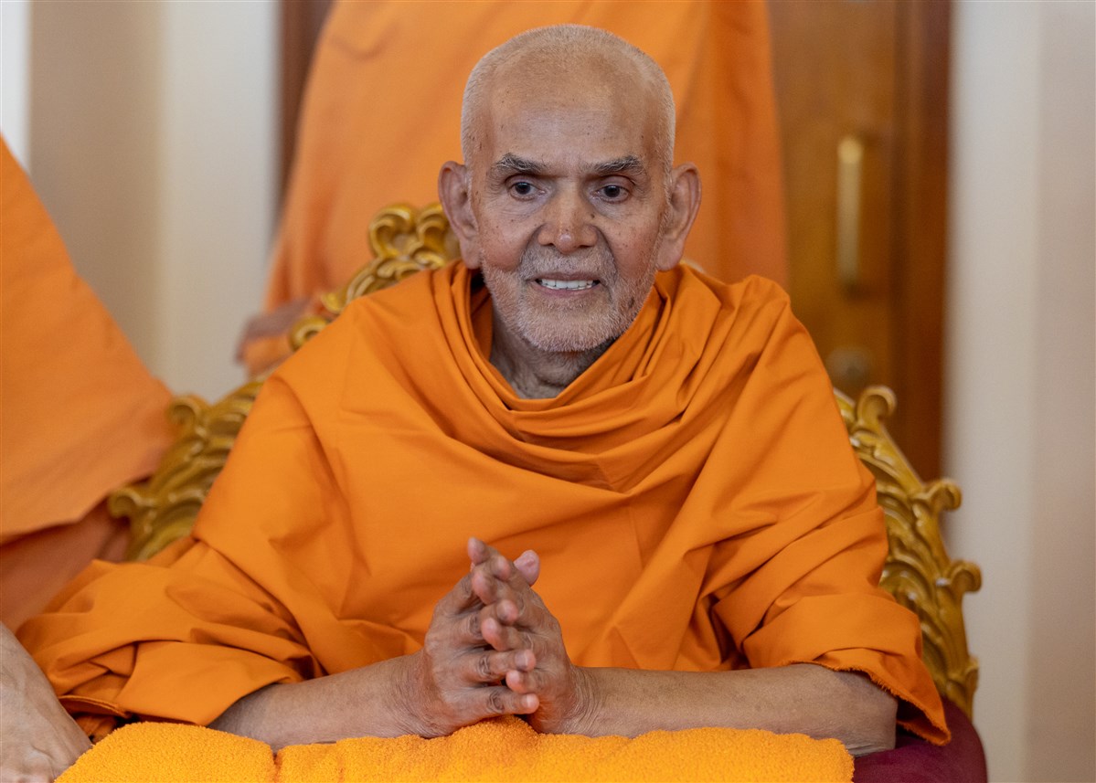 Param Pujya Mahant Swami Maharaj greets swamis and sadhaks with folded hands on his way to the upper sanctum