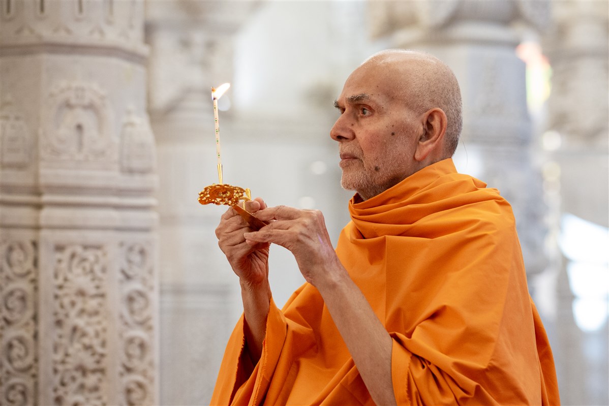 Swamishri performing the morning arti