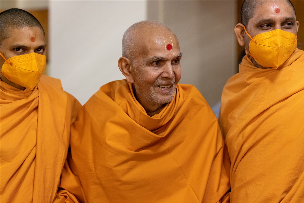Swamishri shares a light moment with swamis after departing from the morning assembly