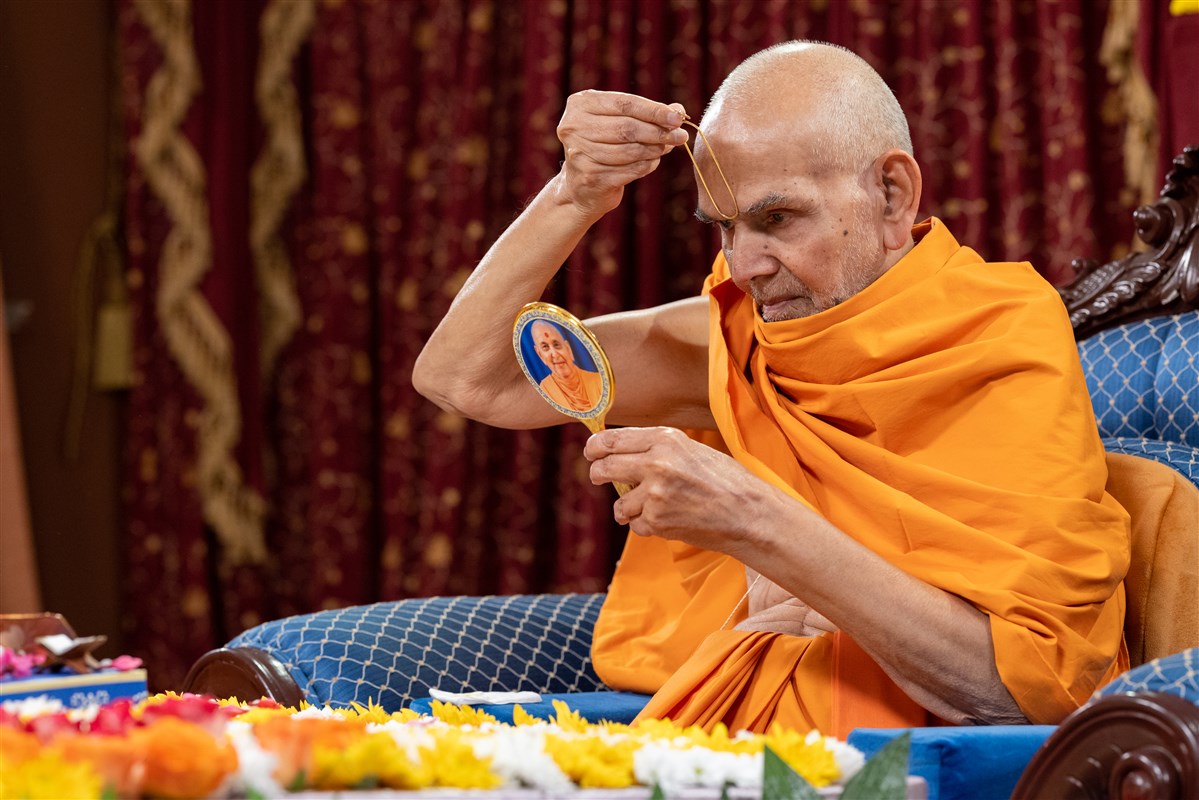 Swamishri commences his morning puja by applying a tilak on his forehead