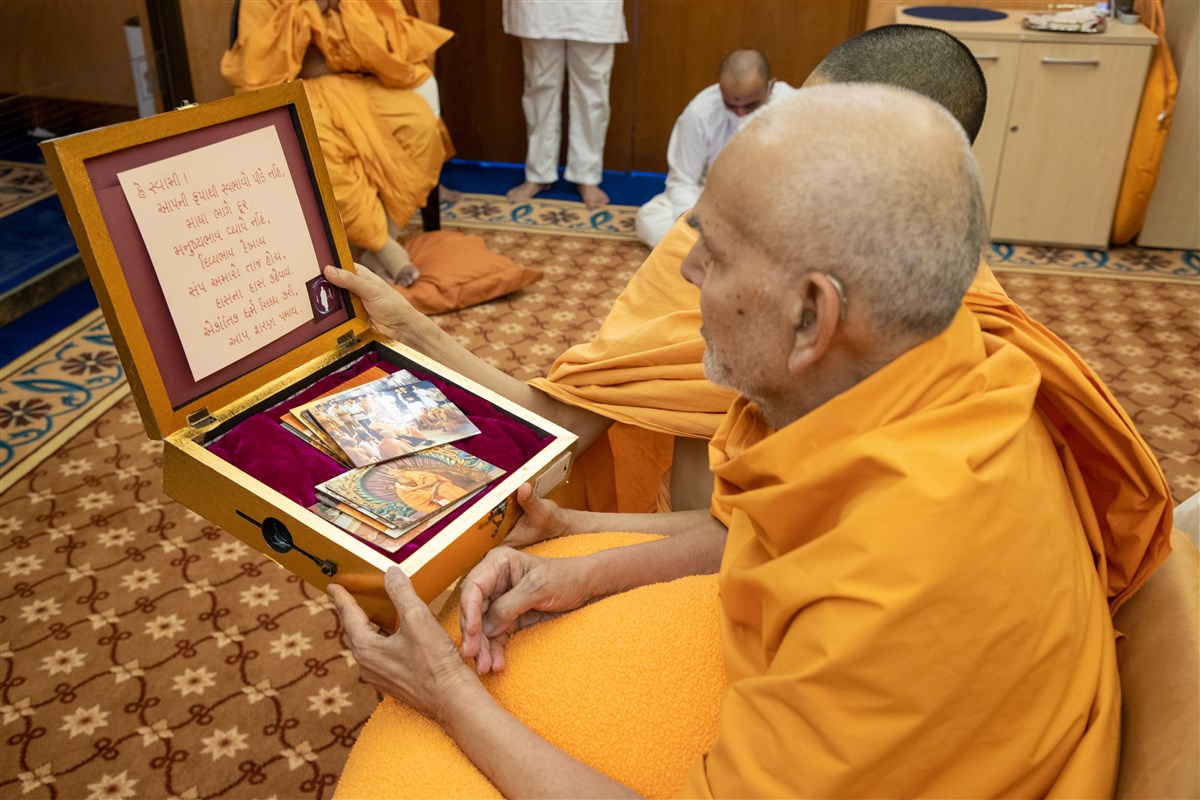Swamishri observes the decorative offering and reads the mahilas' prayer