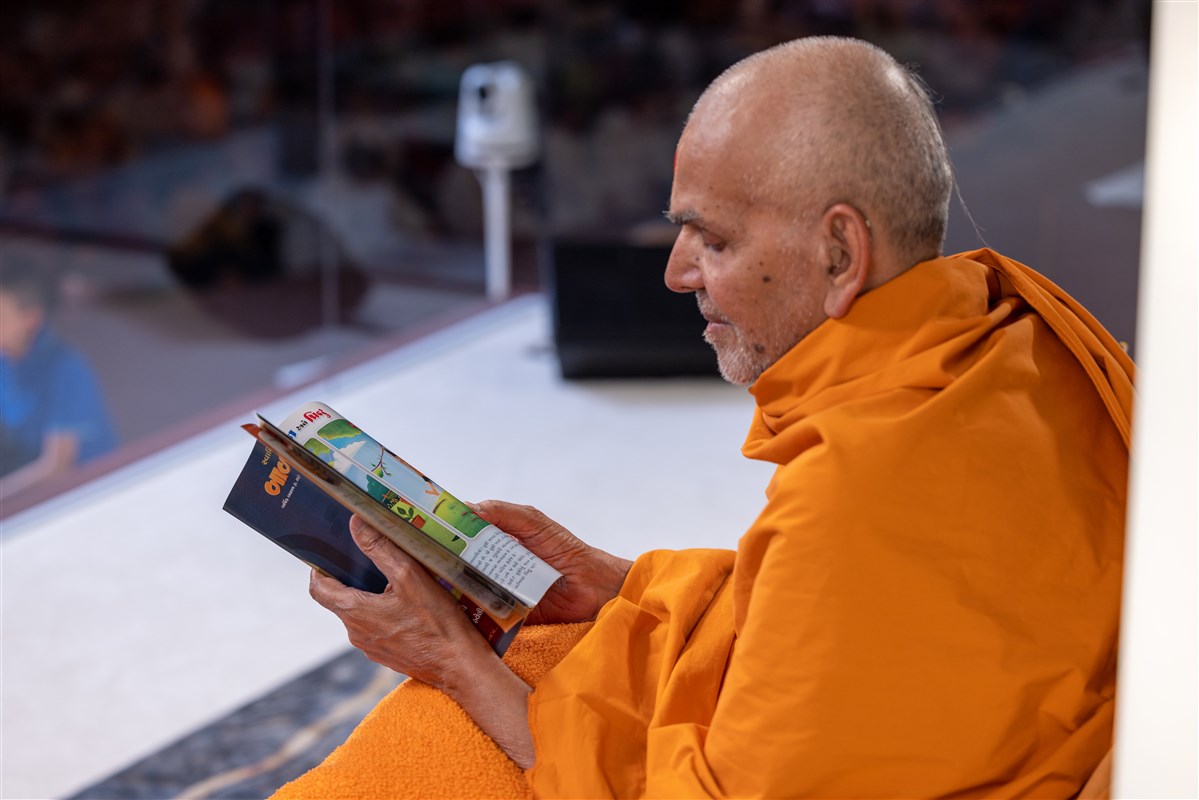 Swamishri leafs through the latest issue of Bal Prakash, which he reads invariably every month