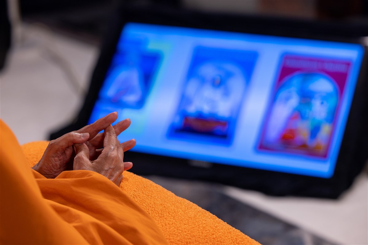 Swamishri watches a short video about the Satsang Exam books