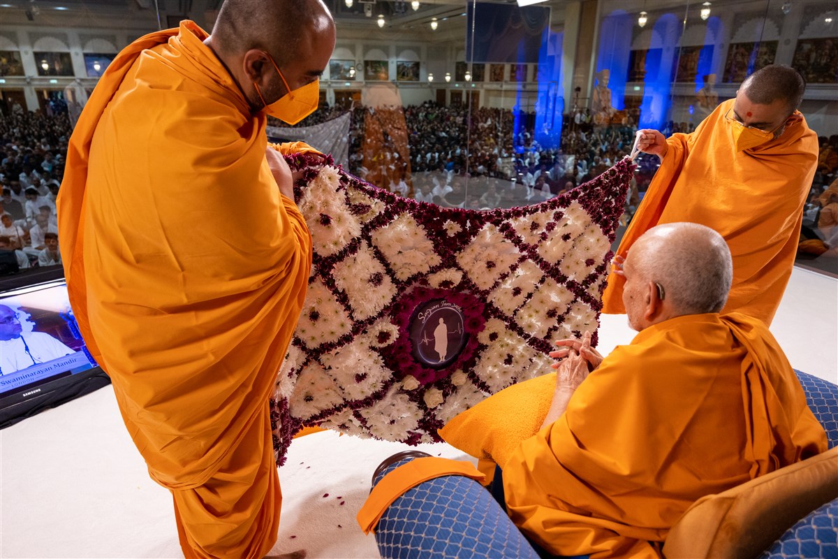 Yagnatilakdas Swami and Tyagratnadas Swami present a decorative shawl to Swamishri