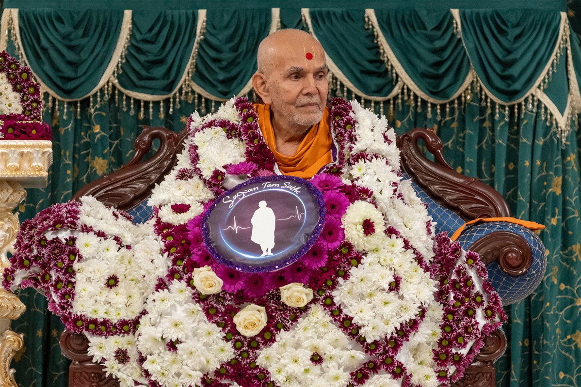 Swamishri accepts the decorative shawl<br>To learn about the Mahila Din, please click <a href="https://www.baps.org/News/2023/Sagpan-Tam-Sathe--Mahila-Din-23540.aspx" target="blank" style="text-decoration:underline; color:blue;" >here</a>