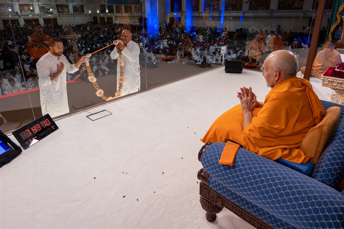 Swamishri accepts a decorative garland made of almonds by the mahilas