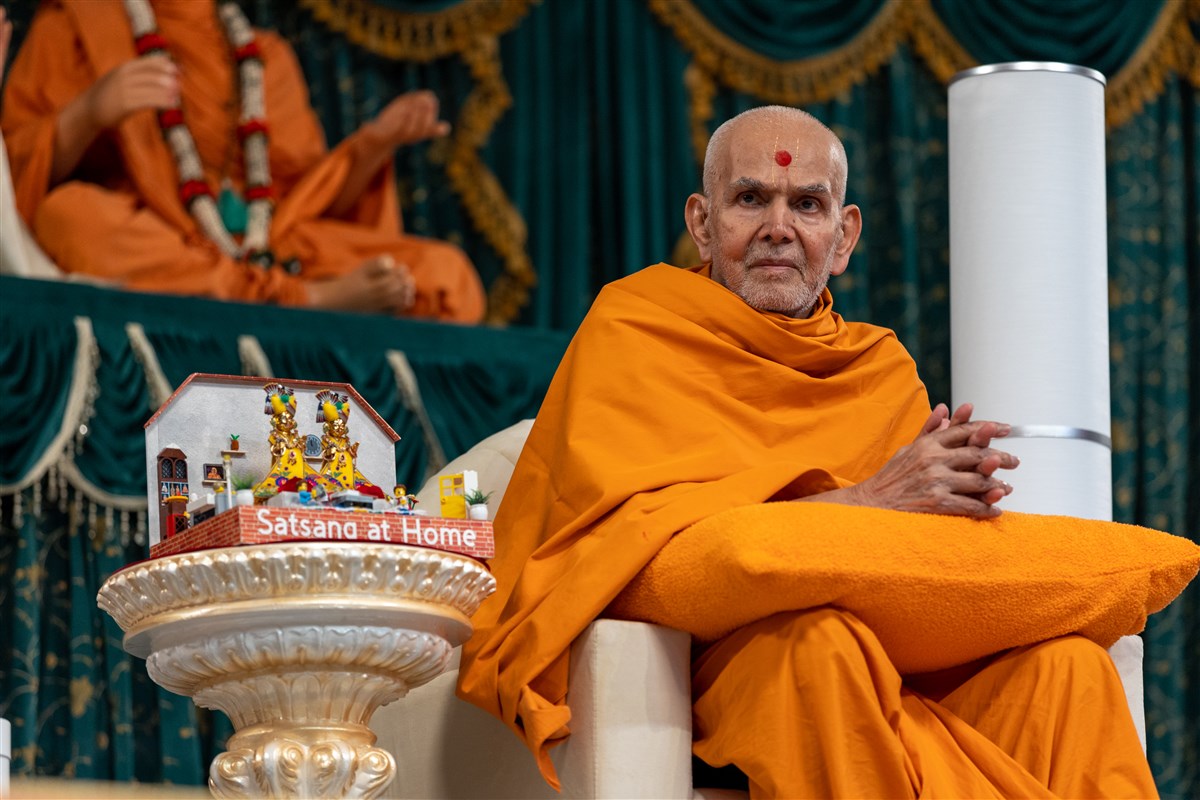 Swamishri listens intently as the father in the skit engages in guna-kathan (positive talk) of his family members