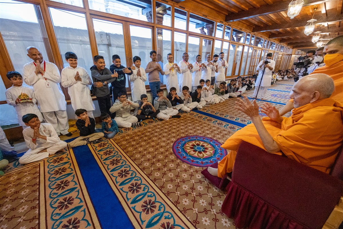 Swamishri blesses young devotees on his way to his morning puja