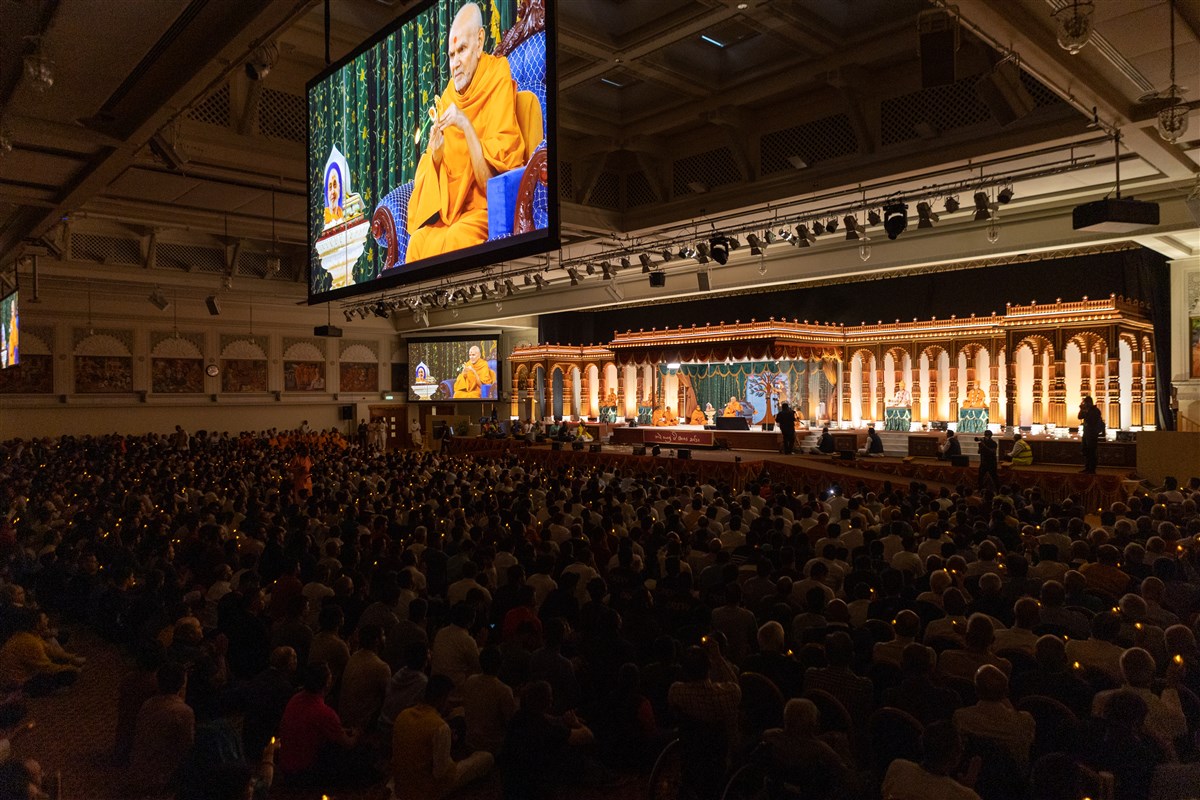 Devotees in the assembly all join in offering the evening arti