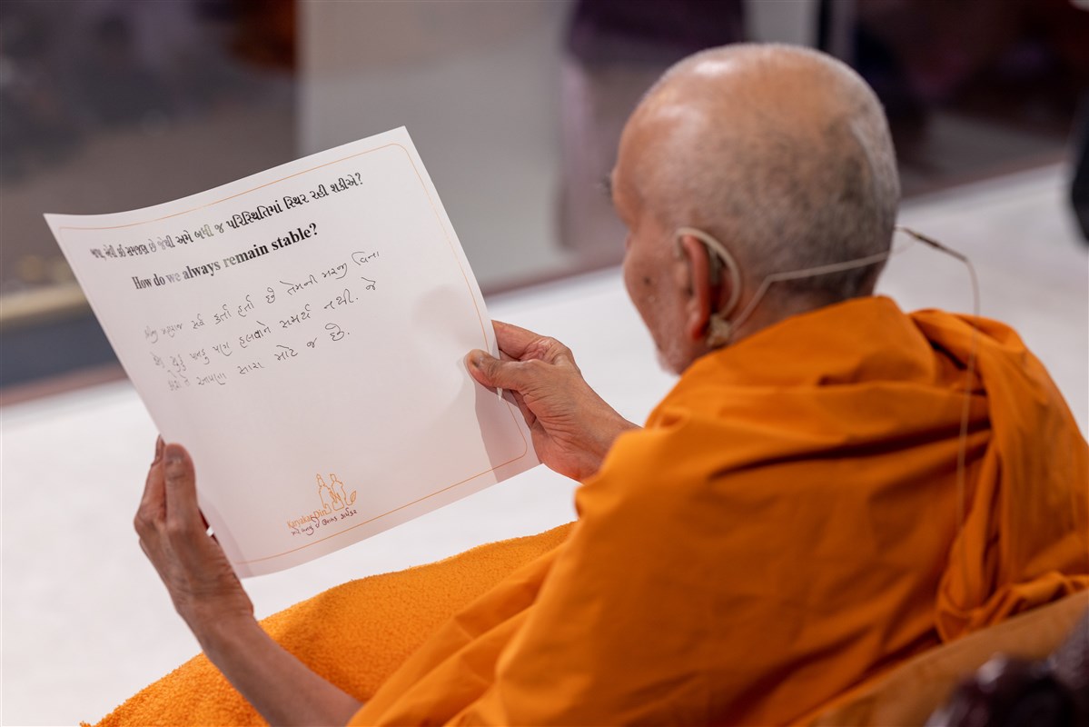 When asked, 'How do we always remain stable?', Swamishri reads out his written response...