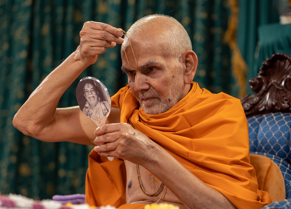 Swamishri commences his morning puja by applying a tilak on his forehead