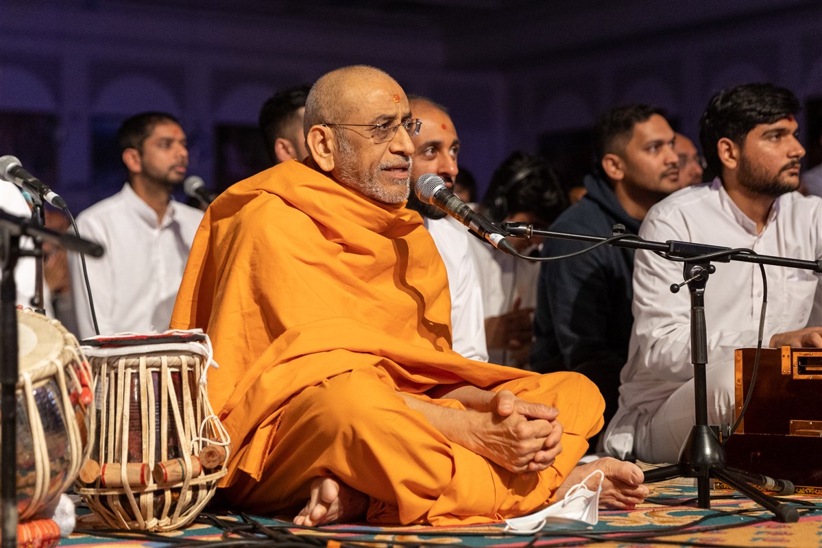 Aksharviharidas Swami sings the dhun while Swamishri performs his puja