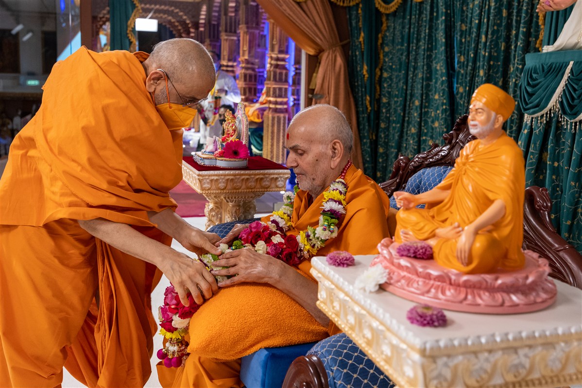 Aksharviharidas Swami honours Swamishri with a fresh flower garland