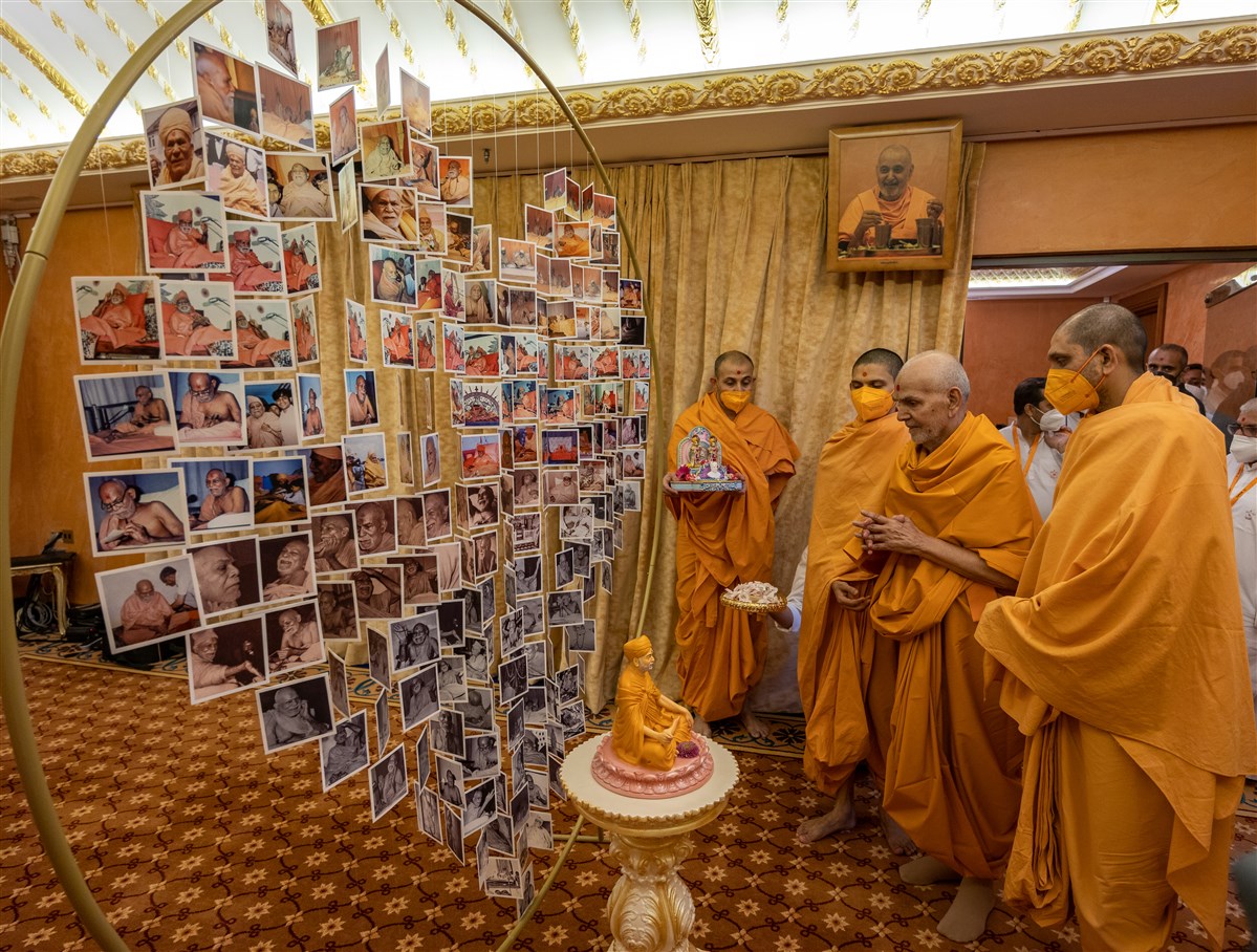 Swamishri observes the decorative display of Yogiji Maharaj's photographs