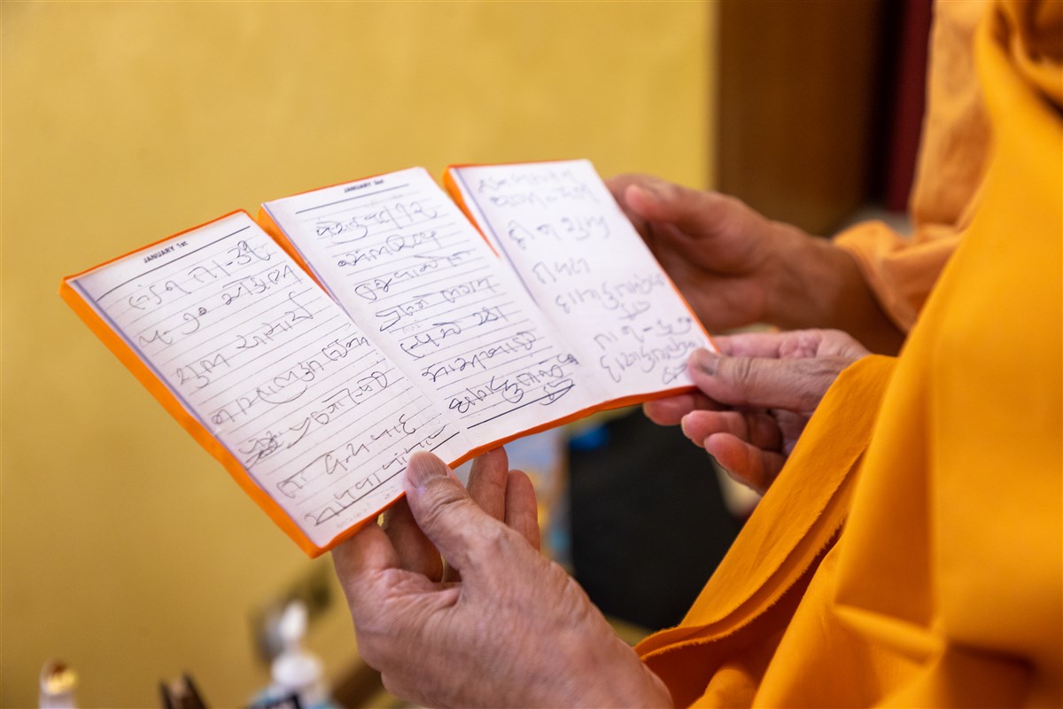 Swamishri observes the handwritten diary pages of Yogiji Maharaj from his stay in London in 1970