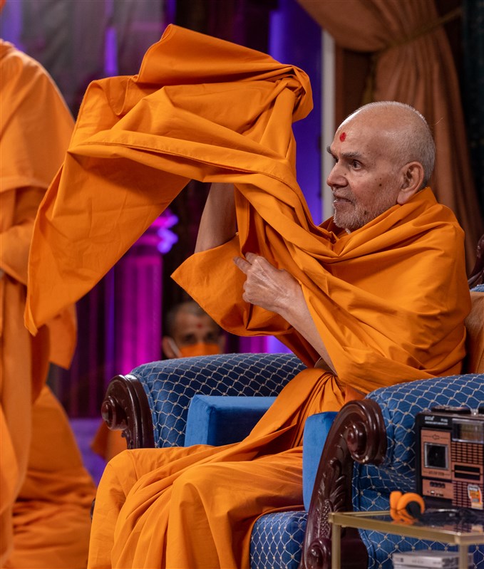 Swamishri enacting how Yogiji Maharaj used to thrash his upper garment