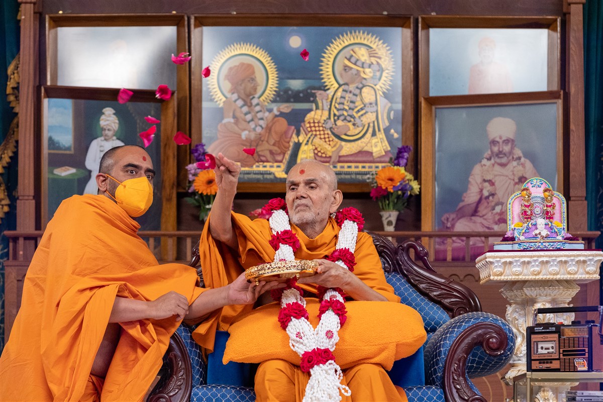 Swamishri showers the rose petals upon the devotees