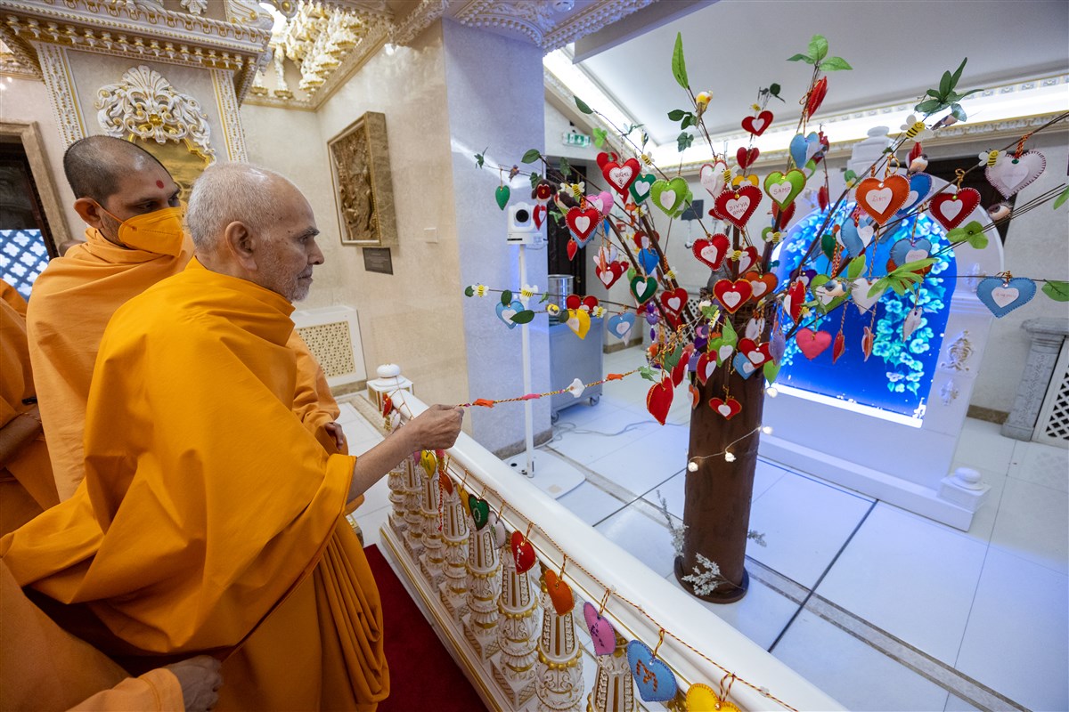 Swamishri interacts with a decorative tree prepared by the vadils