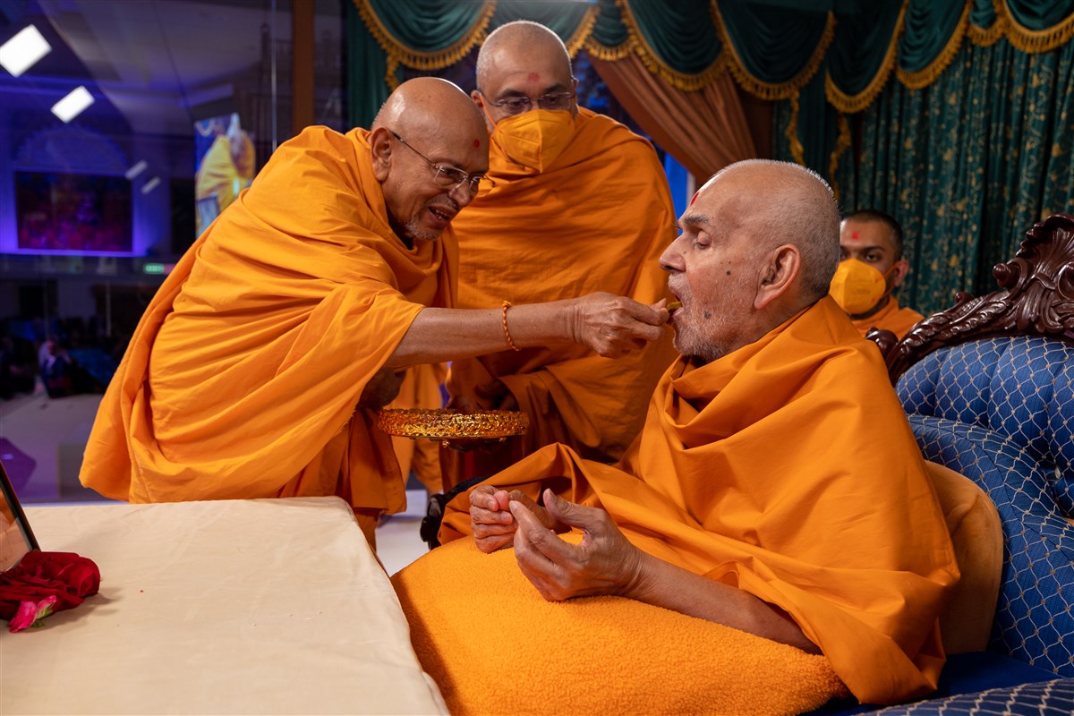 Tyagvallabhdas Swami fed Swamishri a small morsel of puran poli in celebration of Yogi Jayanti