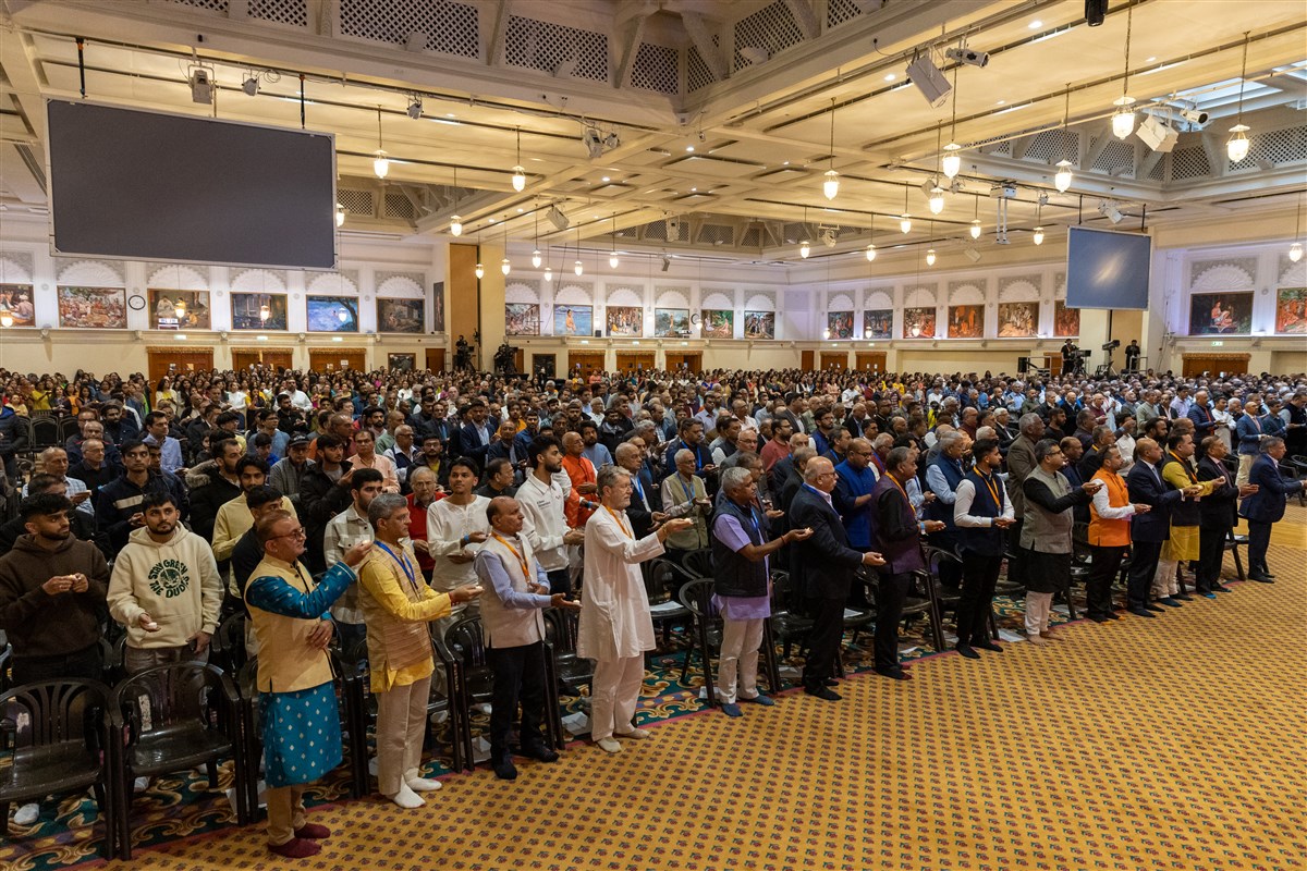 Guests join Swamishri in the evening arti