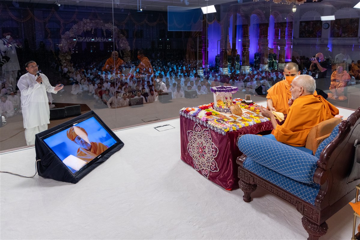 A youth recites scriptural passages in Swamishri's puja