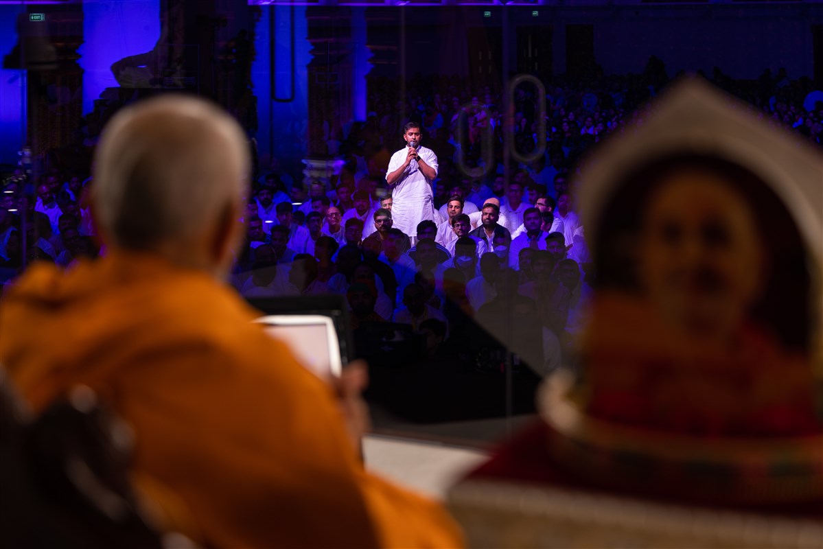A youth asks Swamishri a question as part of an interactive session in the special programme