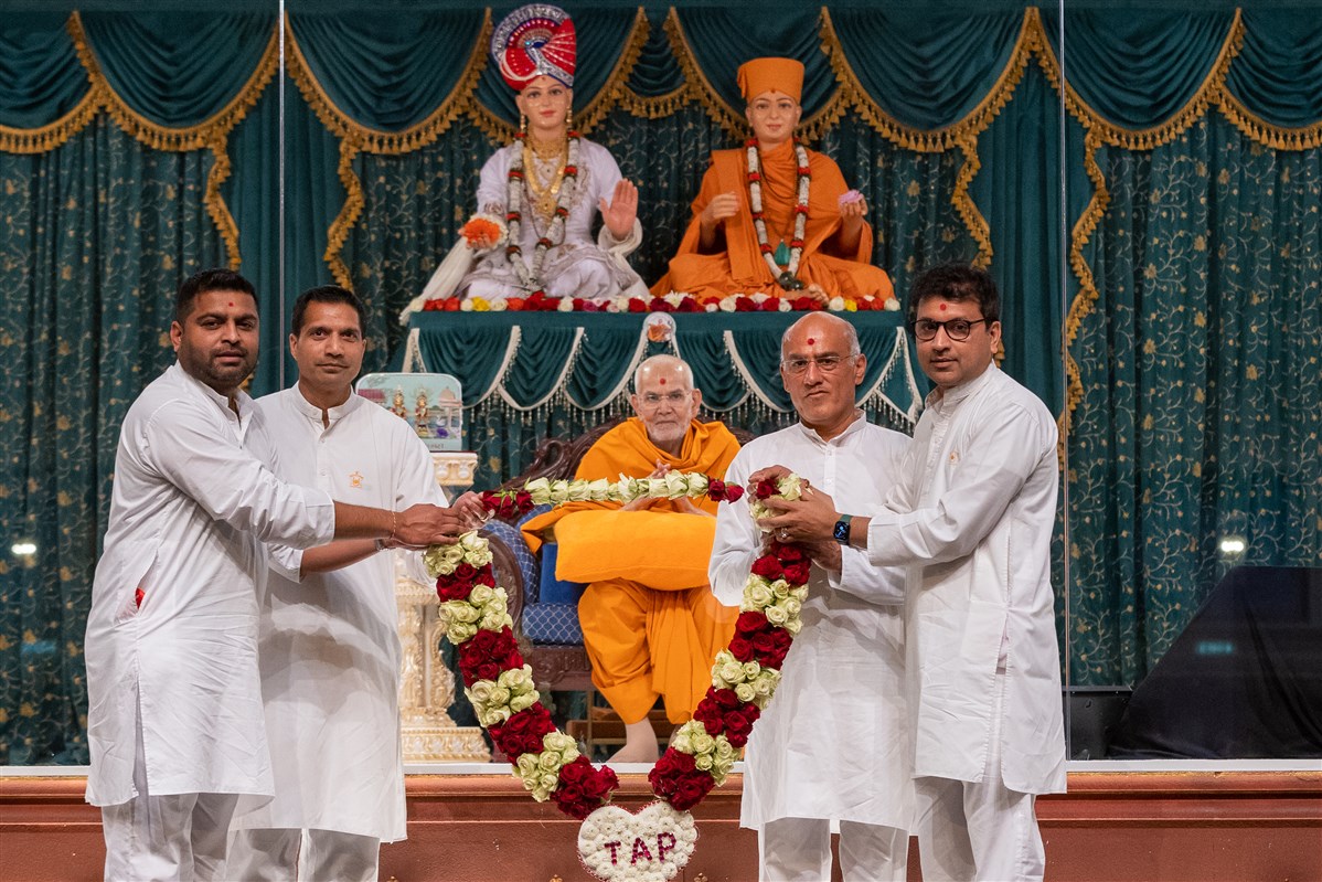 Sanyukta Mandal volunteers honour Swamishri with a garland of fresh roses