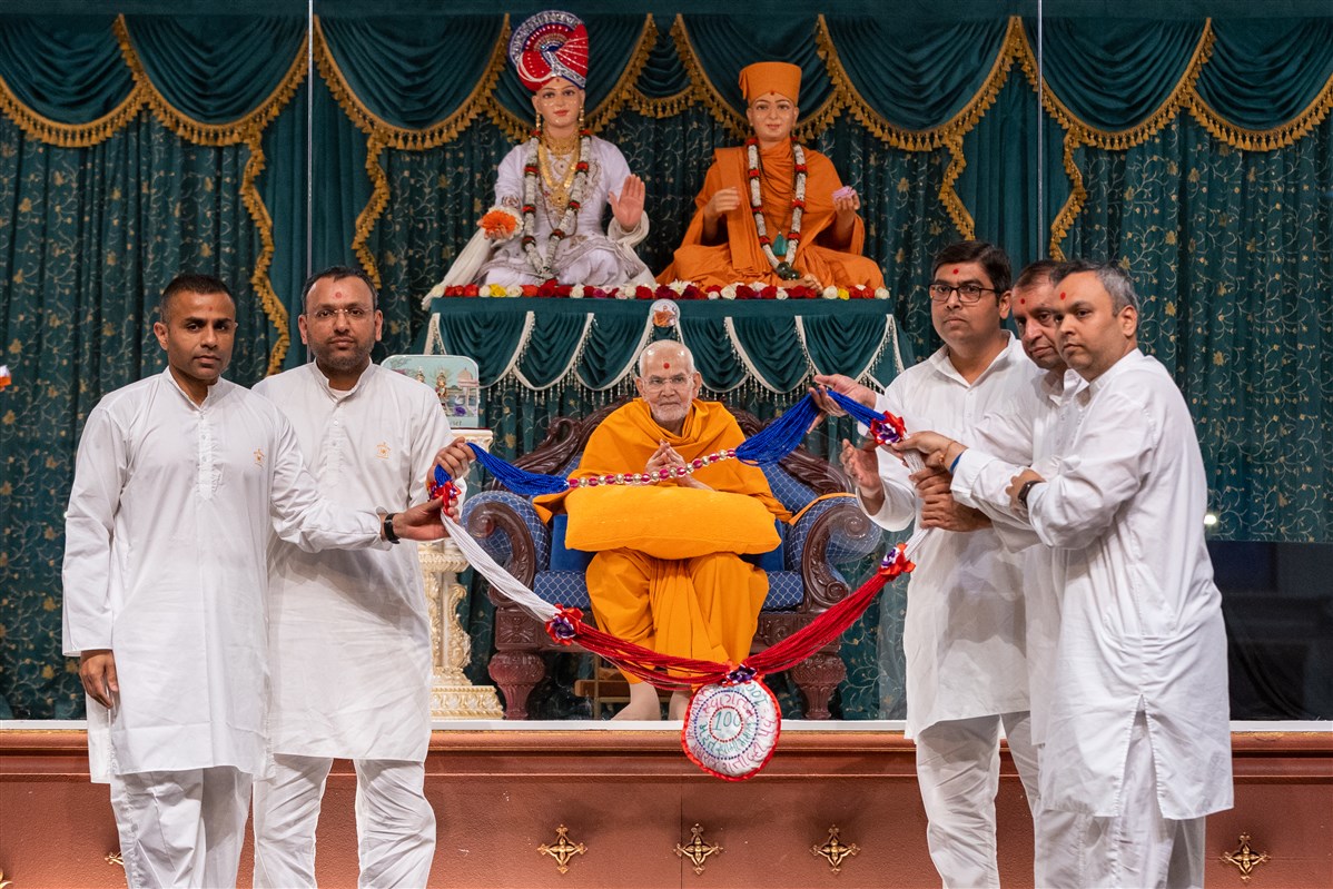 Sanyukta Mandal volunteers honour Swamishri with a decorative garland