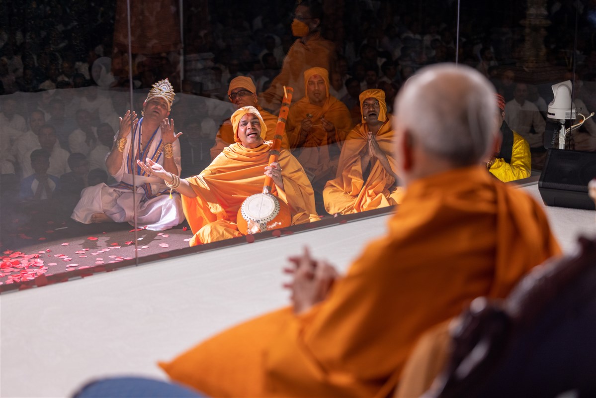 Swamishri watches the drama unfold as performers sing the kirtan, <i>‘Bolyā Shri Hari re, sāmbhalo nar-nāri harijan’</i>