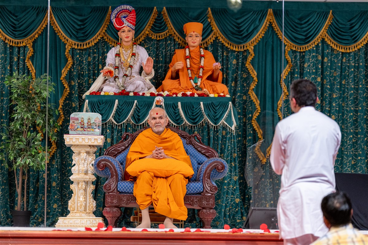 ...as Swamishri listens attentively