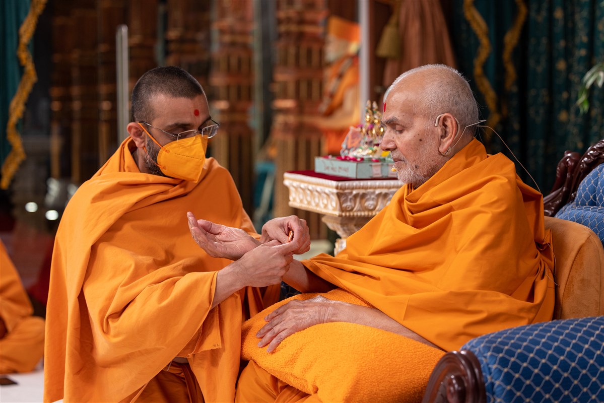 Tyagratnadas Swami ties a nadachhadi to Swamishri, symbolising the sacred bond with the Satpurush
