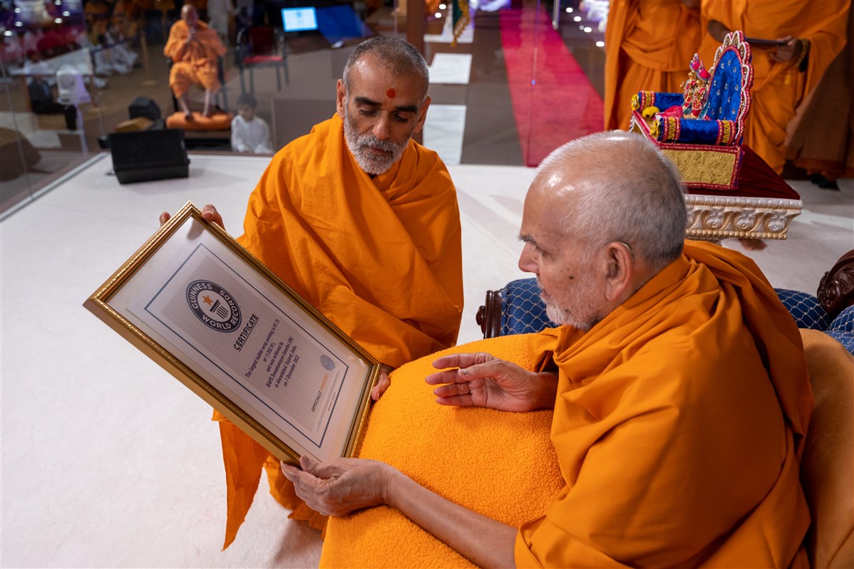 Anandswarupdas Swami presents Swamishri with a certificate from Guinness World Records