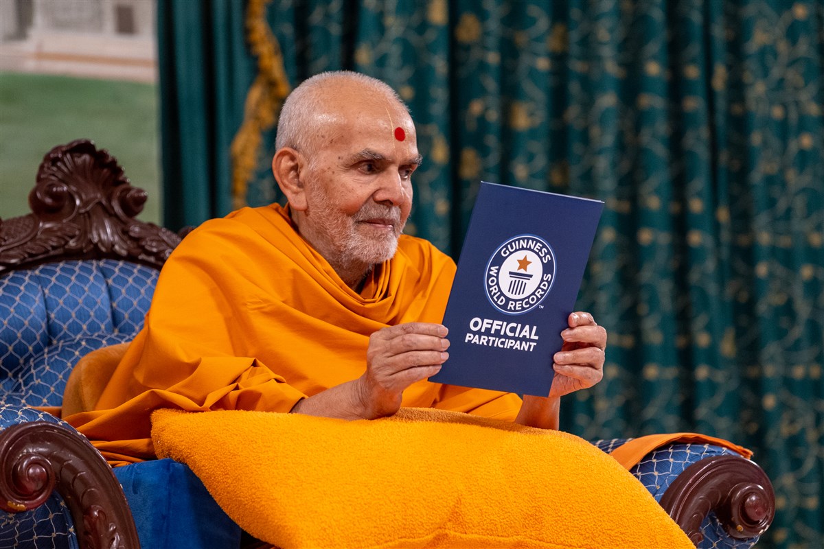 Swamishri presents the participant certificate to the assembly