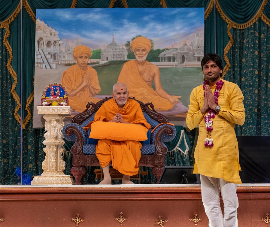 Artist Paresh Kakadia, painter of the artwork behind Swamishri, receives Swamishri's blessings