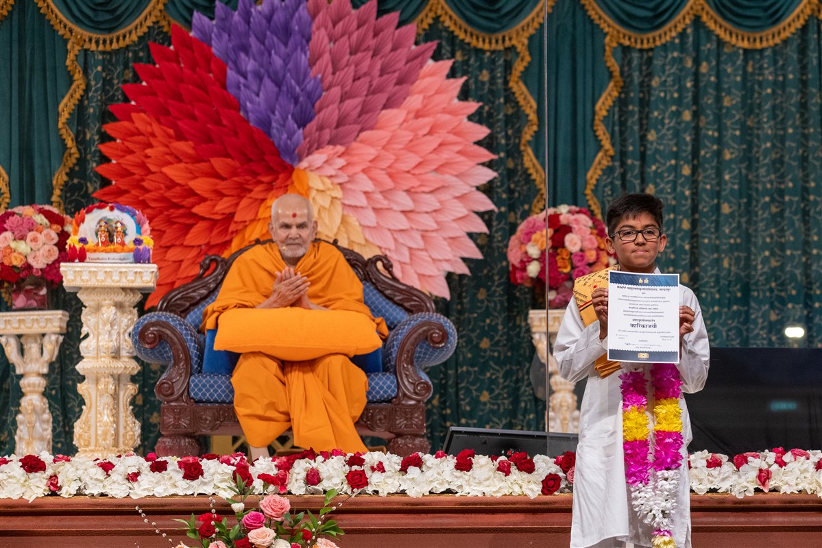 Swamishri blessing and applauding 11-year-old Maharshi