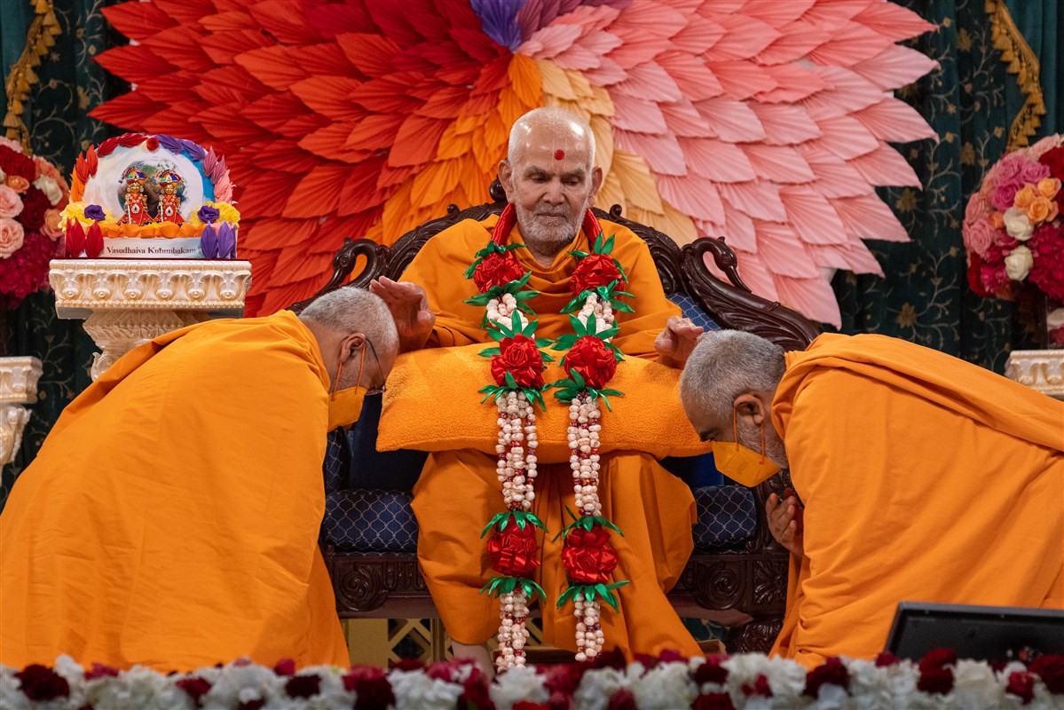 Yogvivekdas Swami and Prabuddhmunidas Swami honour Swamishri with a decorative garland