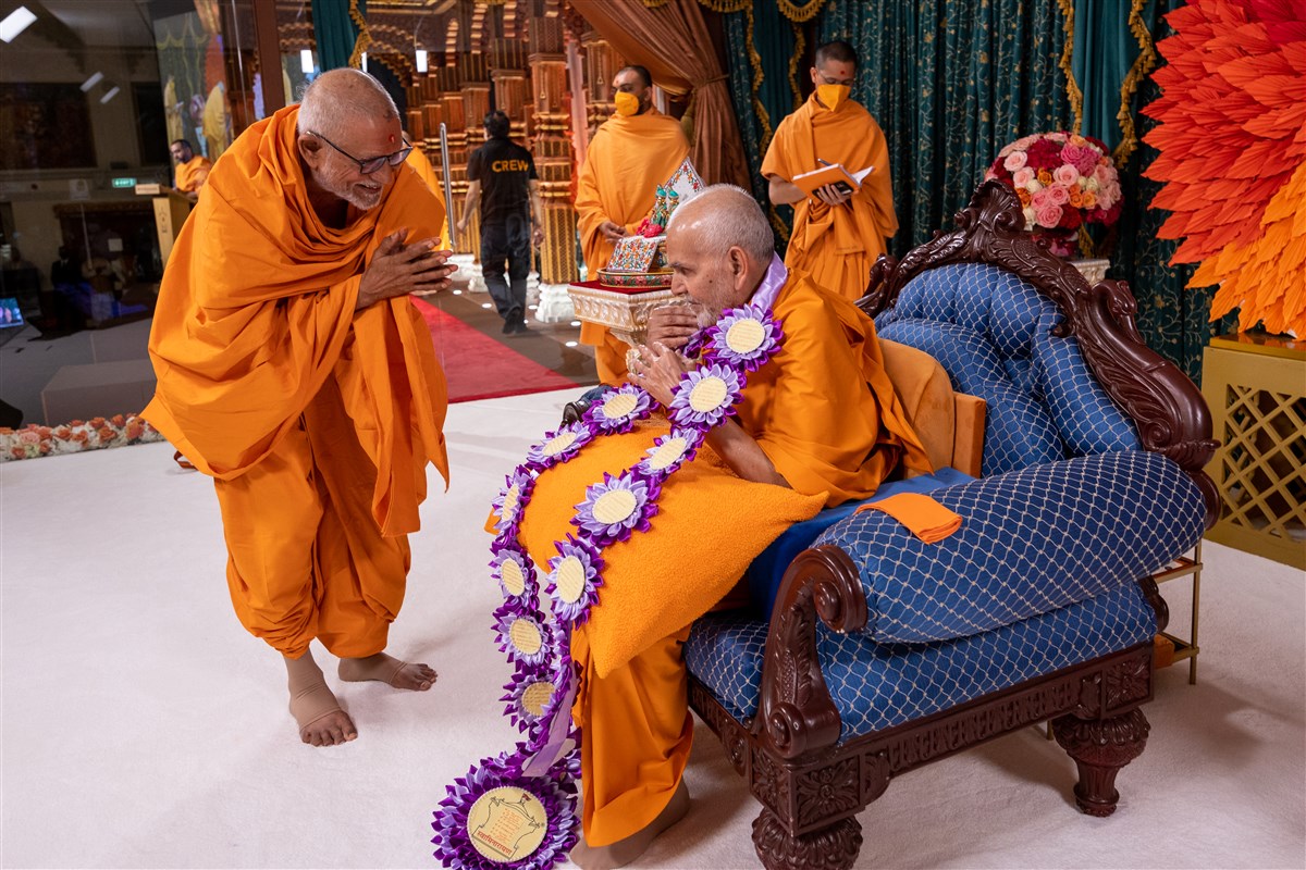 Sadguru Bhaktipriyadas Swami (‘Kothari Swami’) honours Swamishri with a decorative garland
