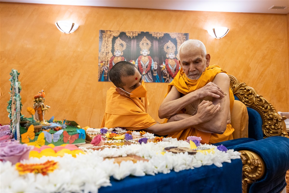 Swamishri applies a tilak to his arm