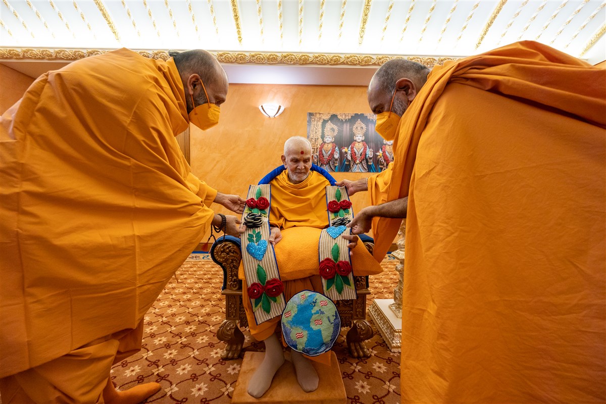 Rushirajdas Swami and Yogivallabhdas Swami honour Swamishri with a decorative garland