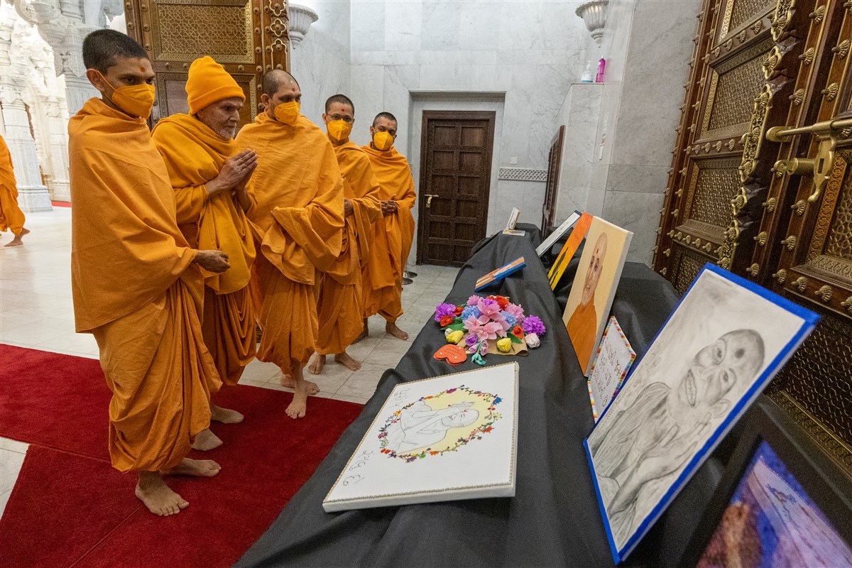 Swamishri observes devotional artwork created by kishores and kishoris