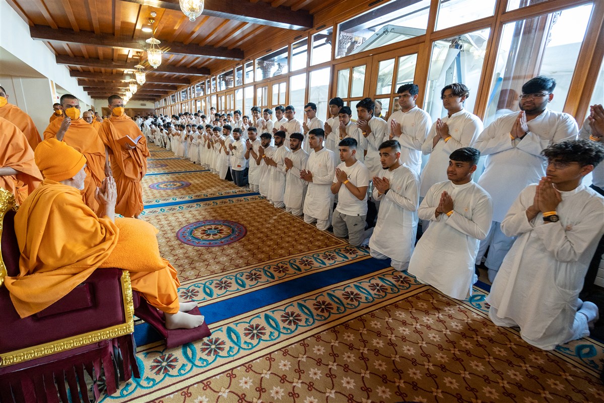 Swamishri blesses youths on his way to his morning puja