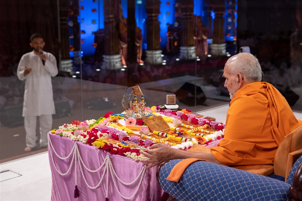 A kishore recites scriptural passages during Swamishri's puja