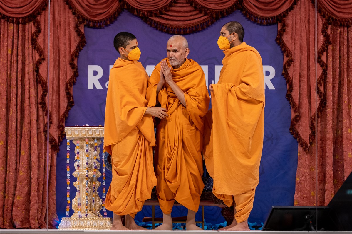 Swamishri greets the assembly with folded hands as he departs